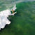 Aerial clip of woman surfing a wave wearing a bikini