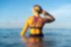 Image of woman sitting in the sea wearing a bikini