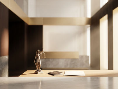 A Lady Justice statuette on a polished desk with a closed passport and legal folio.