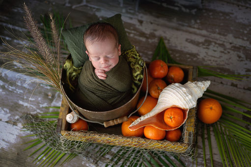 Sleeping newborn baby in a colorful tropical Florida-inspired studio newborn photography setup