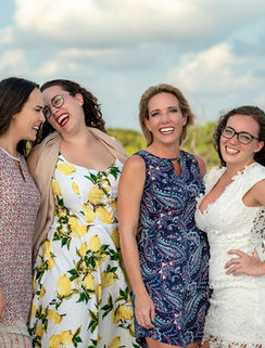 Family sharing a playful moment during a sunset beach photography session at Honeymoon Island in Dunedin, Florida