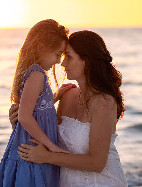 Mother and daughter sharing a sweet moment at sunset during a Honeymoon Island beach photography session