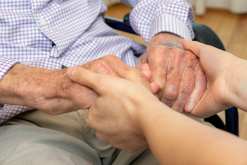 holding senior man's hands