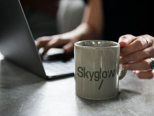 Hands at laptop with Skyglow mug