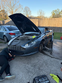 Mobile automotive technician servicing an Aston Martin outdoors as part of Music City Mobile Auto Repair’s on-site repair ser