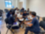 Staff members sitting at desks, working on a group activity.