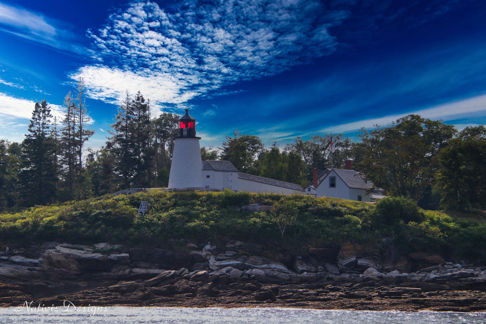 Burnt Island Light with blue skies and red warning light