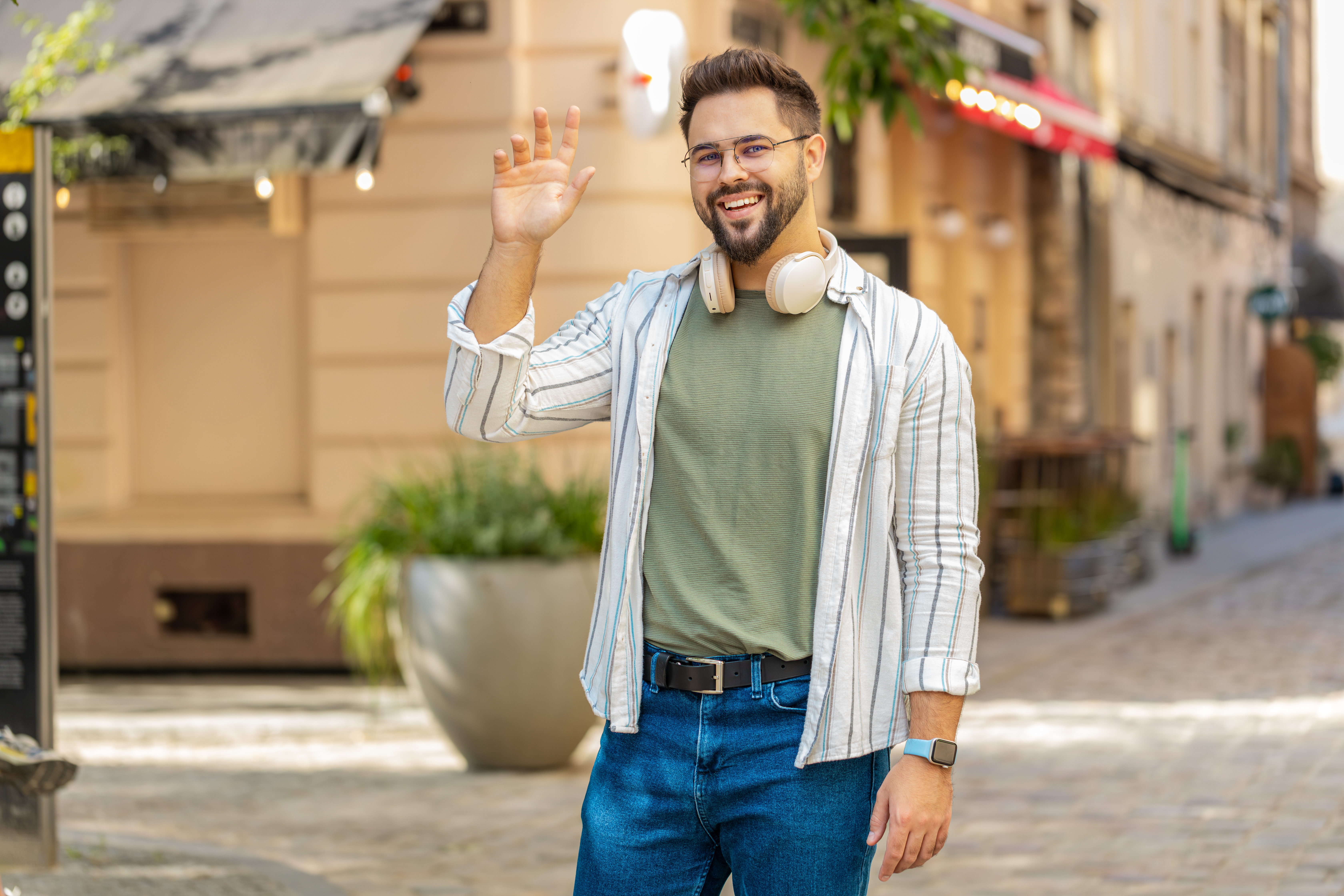 cheerful-young-man-smiling-friendly-camera-waving-hands-gesturing-while-standing-city-stre