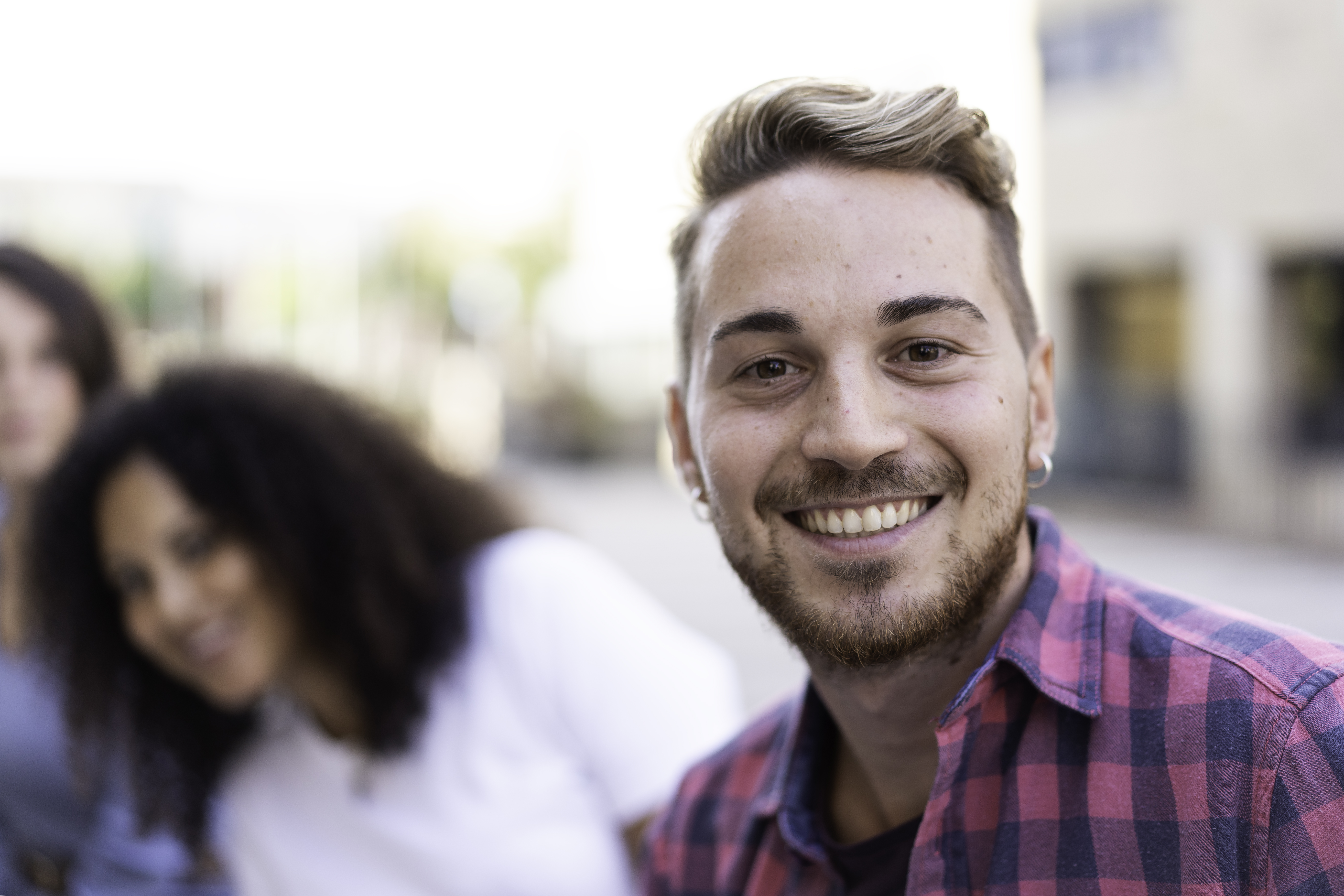 young-man-smiling-camera-having-fun-outdoor-with-multiracial-friends-city-focus-face.jpg