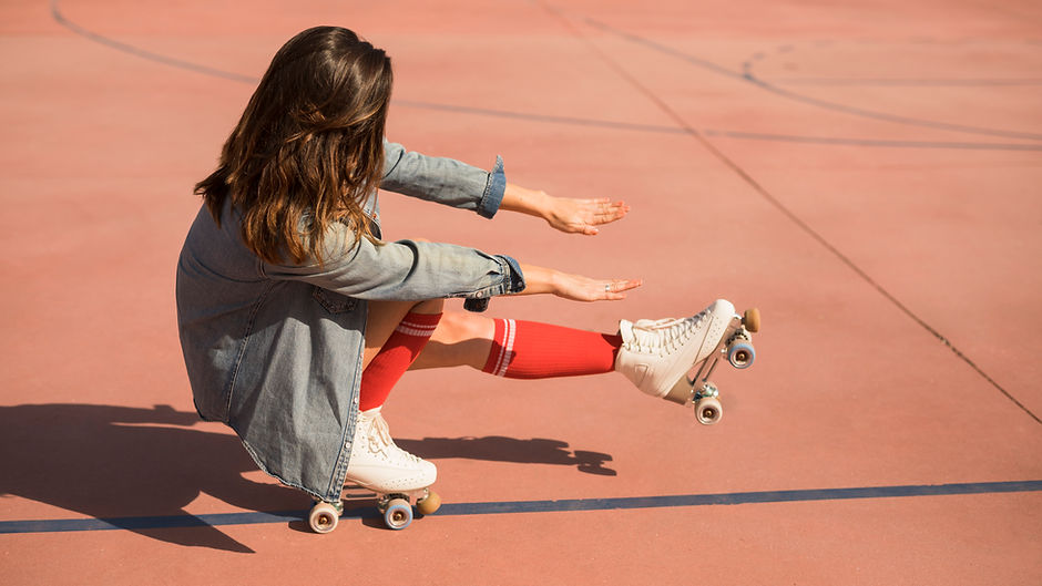 young-woman-wearing-roller-skates-crouching-stretching-her-legs-hand-court.jpg