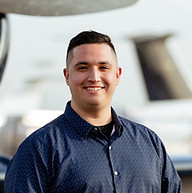 Carson of Luminary Augmenters, in front of an aircraft, representing Fractional COO services for growth.