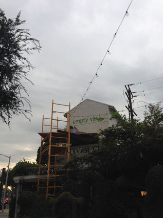 Kat Ford hand painting the Empty Vase logo over their West Hollywood location.