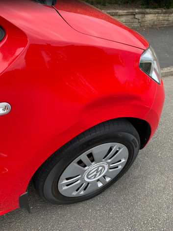 Dented wheel arch of a red Volkswagen