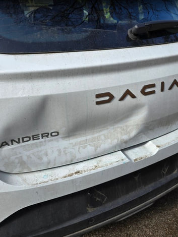 SL Dents | Dented rear door of a white Dacia