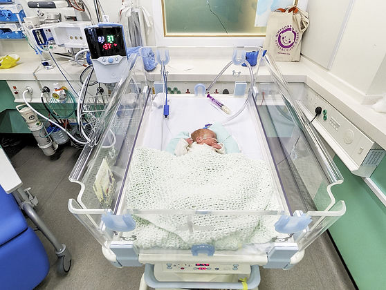 Neonatal baby in open cot