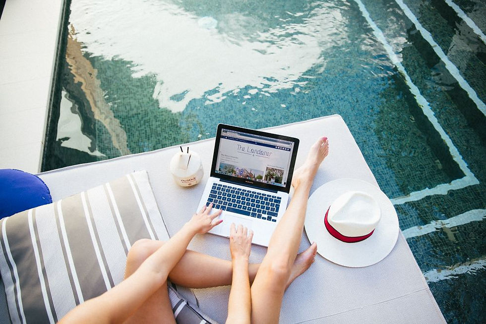 person working on a laptop by the pool