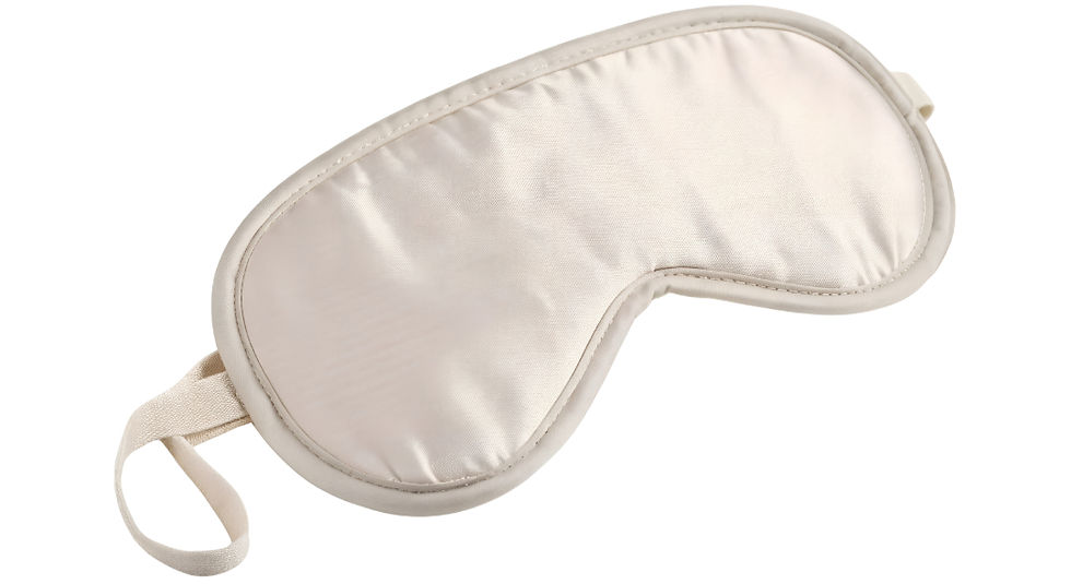 Cream silk sleep mask with an elastic strap against a white background. The texture appears smooth and shiny.
