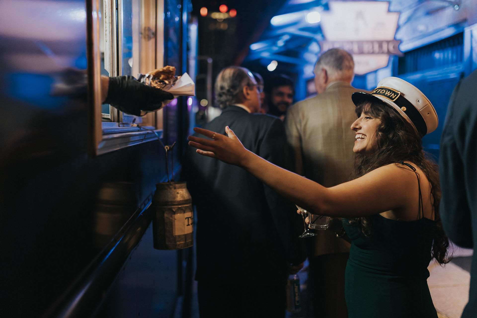 wedding guest being handed a chicken sandwich out fo the window of a fod truck