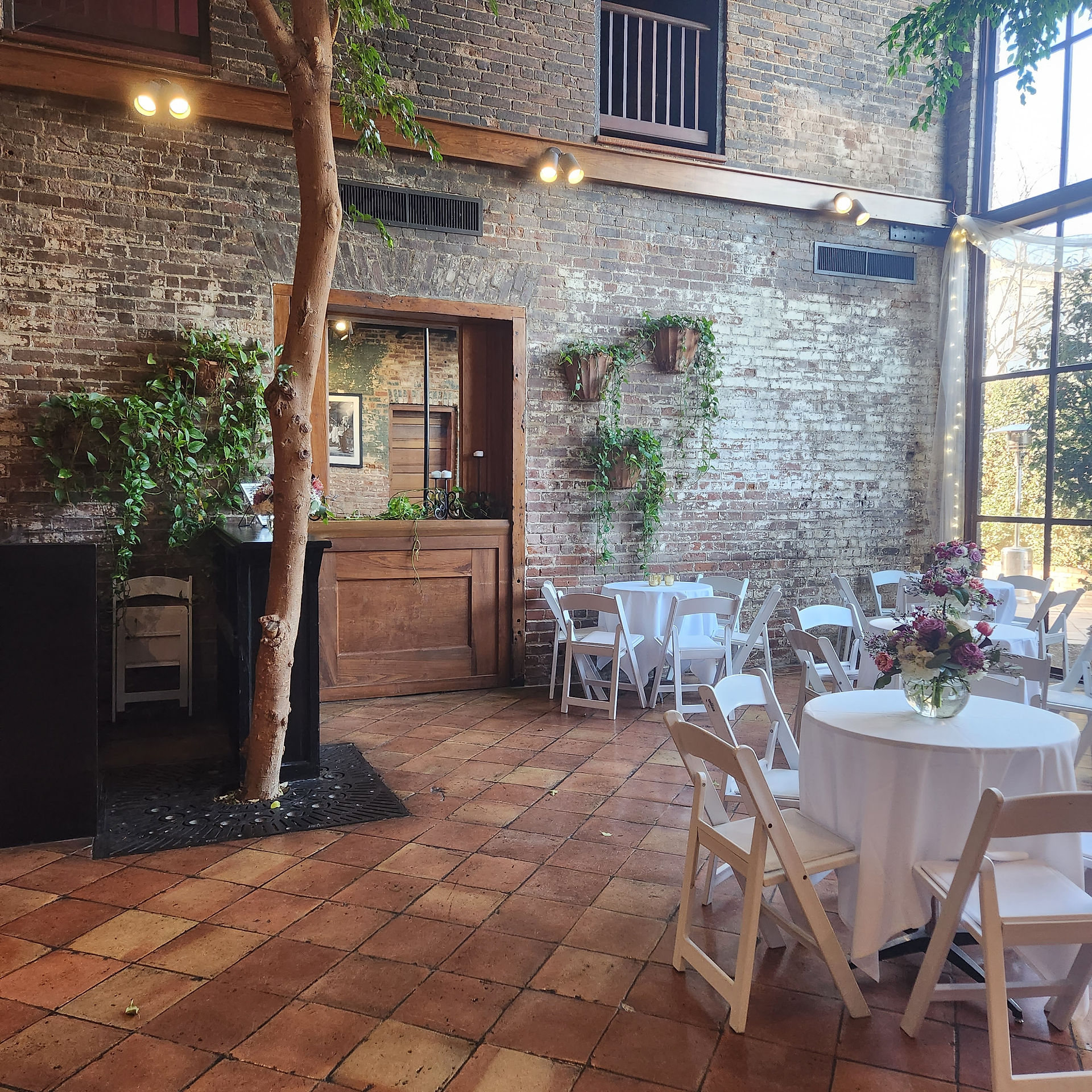 atrium with reception tables and hanging ivy on brick walls
