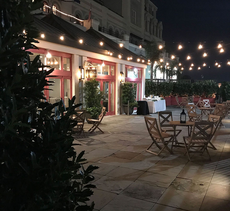 patio with red door, string lights above and wooden patio furiture on the terrace
