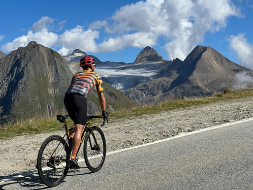 A cyclist on a road bike climbing a hill in the mountains