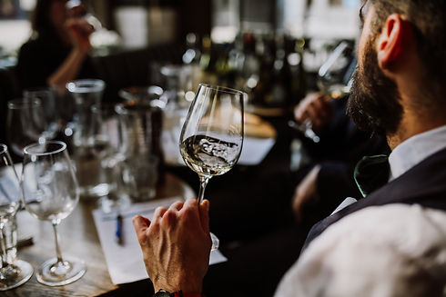 A young European man drinking white wine