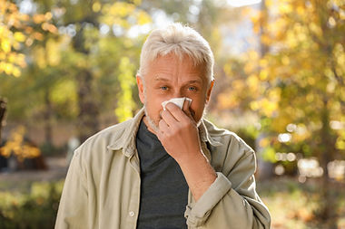 senior-man-with-tissue-blowing-runny-nose-park.jpg