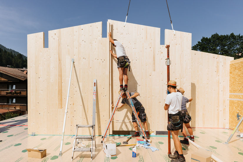 Zimmererteam beim aufstellen der Giebelwände vom Holzhaus