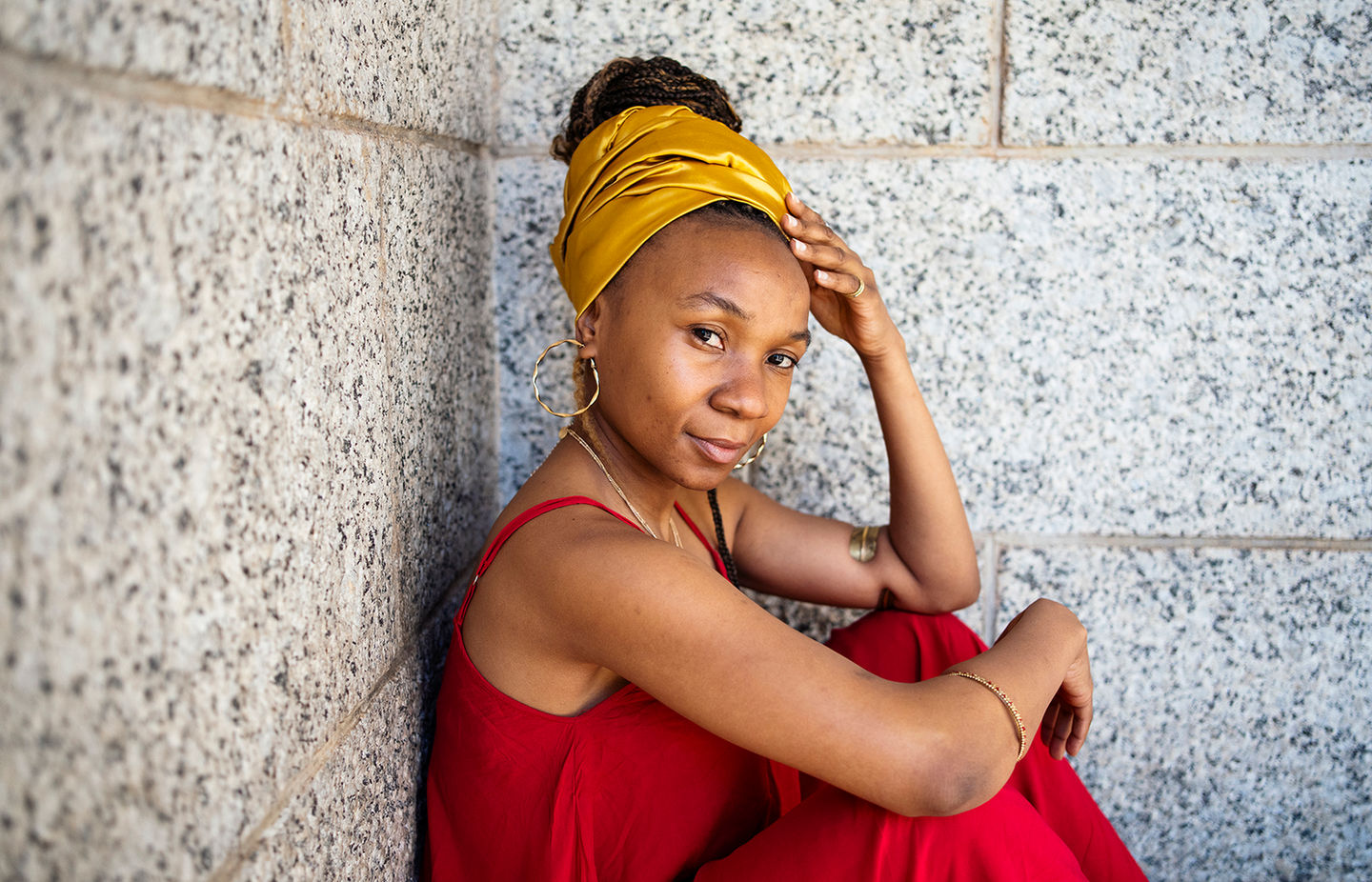 Nicky Lloyd Photography in South Africa & Southern Africa - a lady in red sitting and leaning on a stone wall