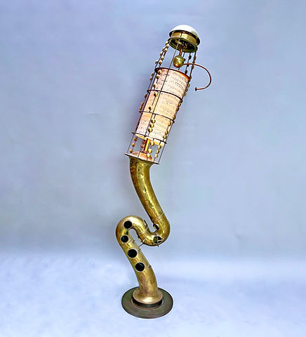 Sculpture made from two tenor saxophone bells, handwritten music paper, and a counterbalanced copper arm topped with a brass sphere.