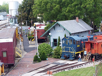 Small train depot with train cars parked outside