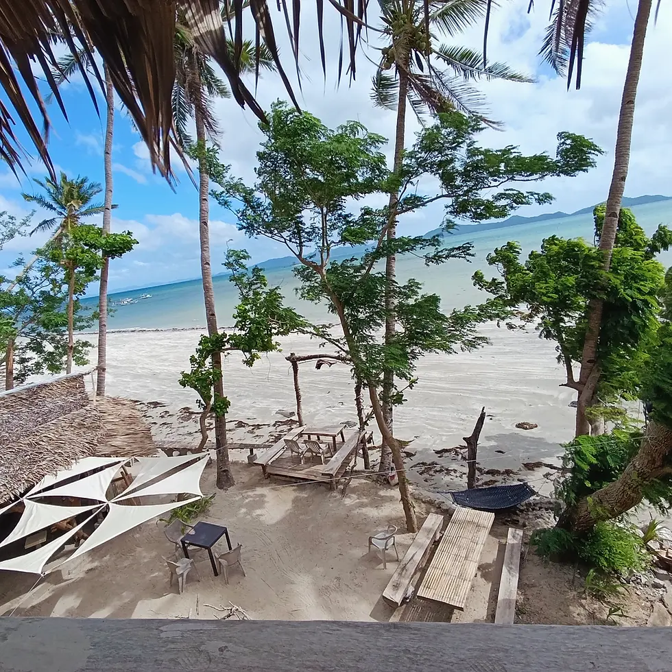 Beachfront view with outdoor seating at Kamp Tapik El Nido