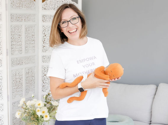 Kathy Rougier holding baby in tiger in the tree pose