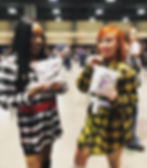 Photo of two young women smiling and holding a Bundle game. They are dressed as Dionne and Cher from Clueless.