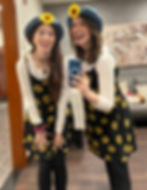 Photo of two women in matching sunflower dresses and matching jean sunflower hats.