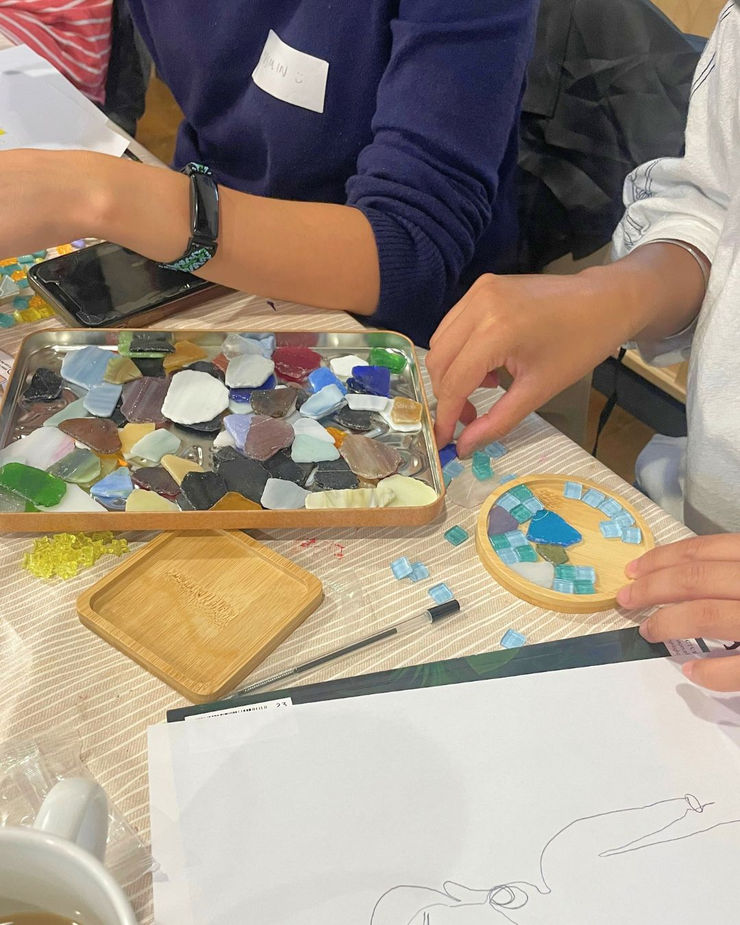 Colourful mosaic tiles arranged for a handmade coaster workshop.