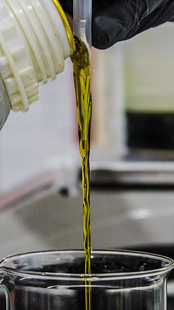pouring fragrance ingredient into beaker
