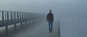 Mann geht durch Nebel