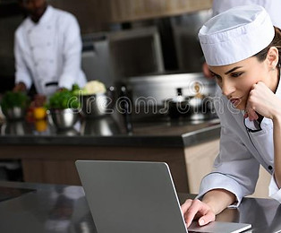 cocinero-atractivo-que-usa-el-ordenador-portátil-127722009.jpg