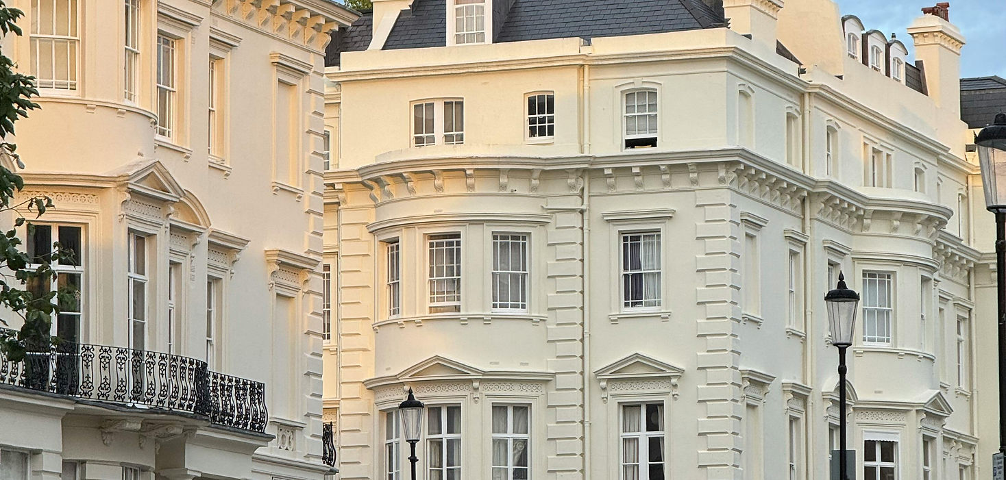 Historic European square with pastel-colored buildings and elegant architecture under a clear blue sky.