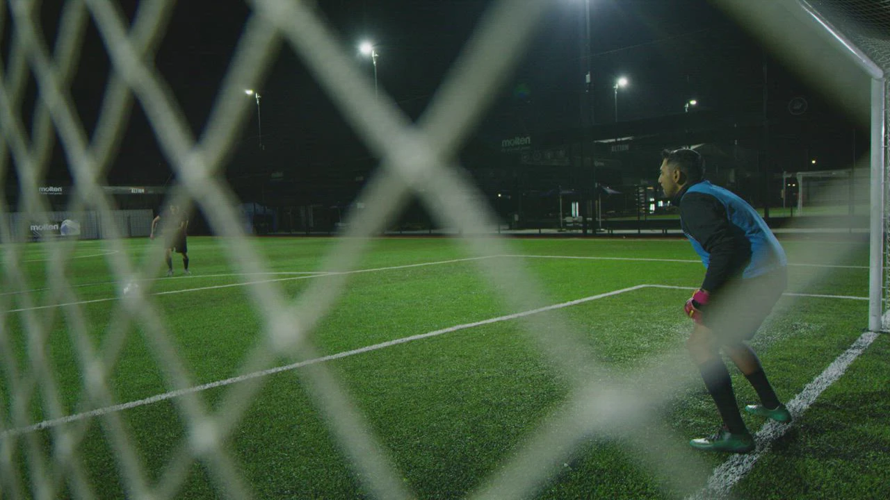 mixkit-penalty-kick-seen-from-behind-the-goal-nets-43495-0.jpg.webp