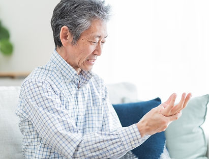 室内で手指の違和感を確認している人物の様子