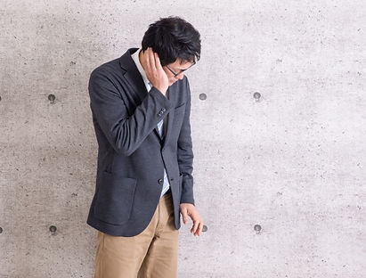 内で耳に手を当てて聞こえにくさを確認している人物の様子