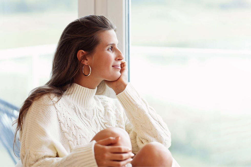 Mulher brasileira olhando pela janela, se sentindo confiante.