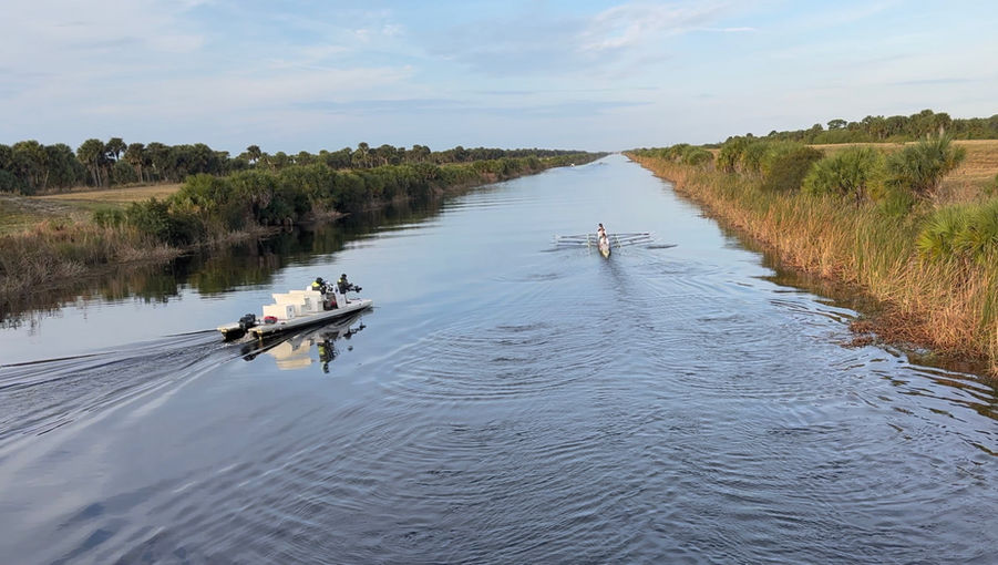 A coaching launch and eight-oared shell on canal