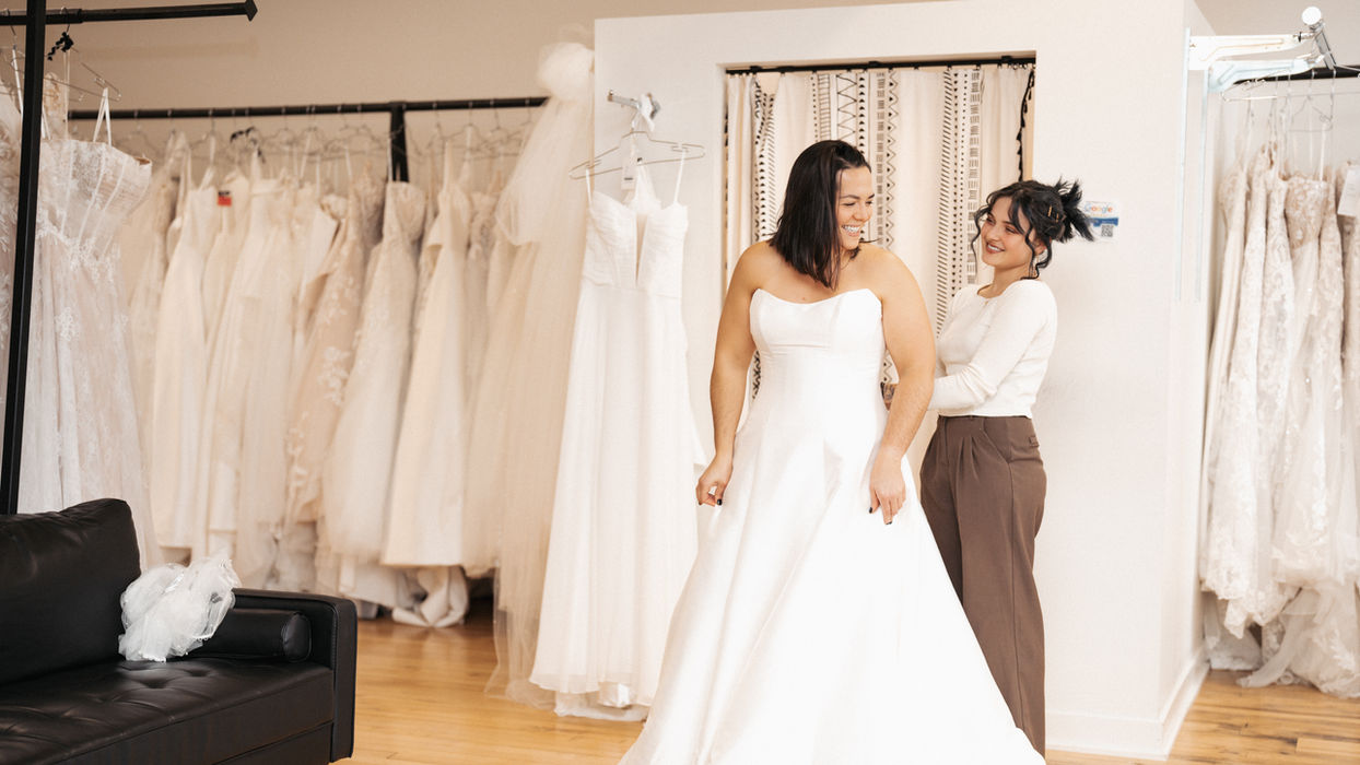 consultant helping bride do up her dress