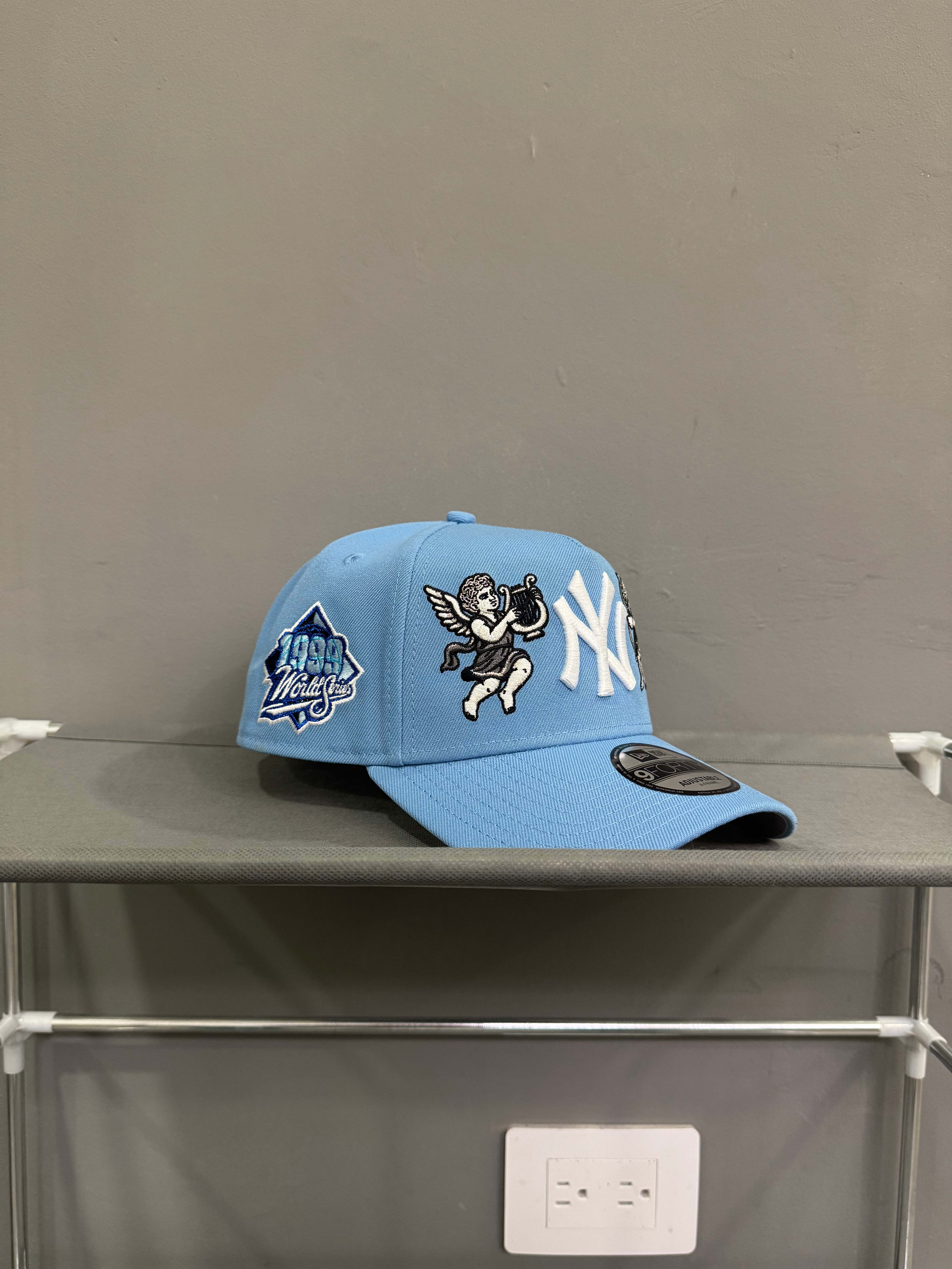 Azul celeste con logo blanco y detalles de ángeles, Yankees 1999 WS