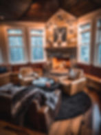 Cozy Whistler chalet living room with a lit fireplace and comfortable seating, professionally photographed to show the warm après-ski atmosphere guests look for in a mountain rental