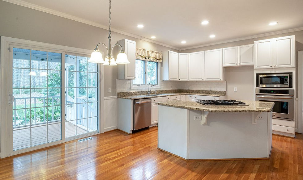 Bright open-plan kitchen with hardwood floors and deck access photographed with professional HDR real estate photography for a Nanaimo, BC listing