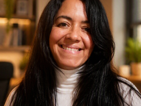 Mulher sorrindo, de cabeloz longos pretos e lisos , com semblante de vencedora